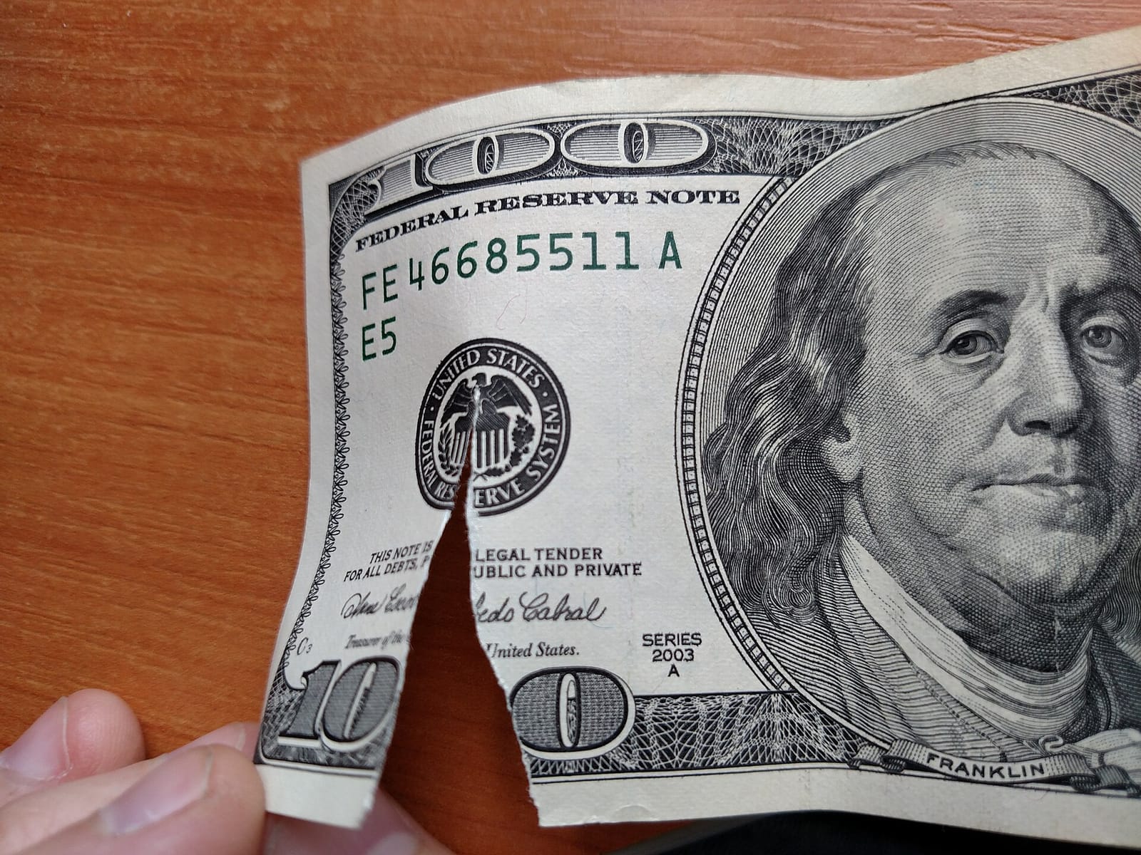 Банкнота 100 доларів США в руці